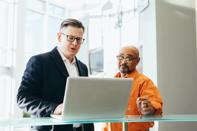 Two persons discuss a project at a computer